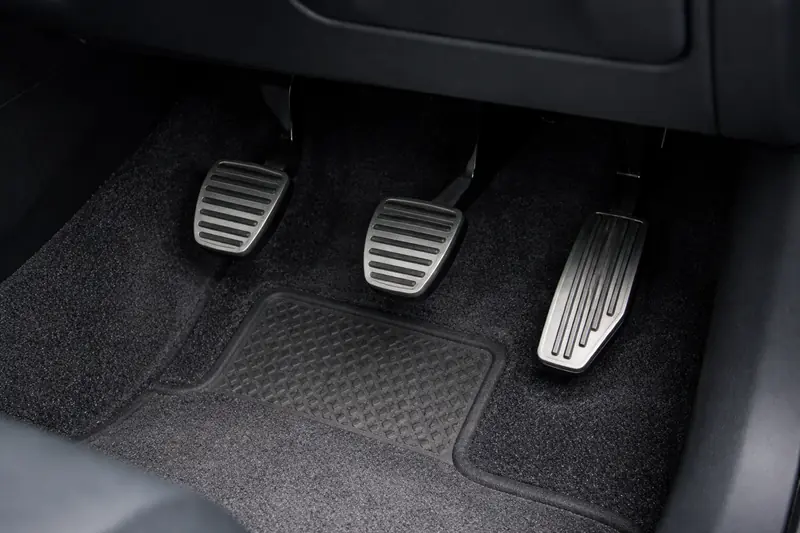 Footwell of a right-hand-drive car showing clutch, brake and accelerator pedals